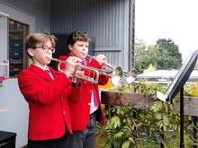 Two  standing playing the trumpet